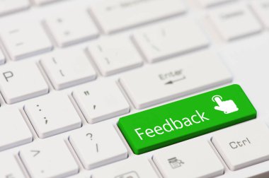 Beyaz dizüstü klavye üzerindeki metin geri bildirim ve dokunmatik parmak simgesiyle yeşil tuş.