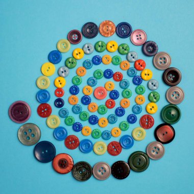 Burnunuzdaki mavi zemin üzerine spiral renkli düğmeleri. Üstten görünüm.