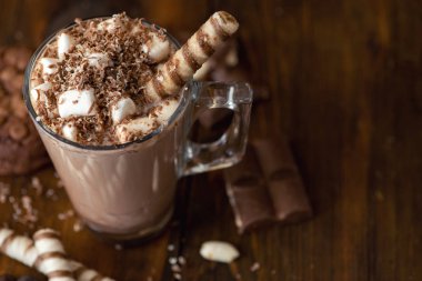 Fincan kakao marshmallows ve koyu ahşap zemin üzerine çikolatalı kurabiye. Üstten görünüm.