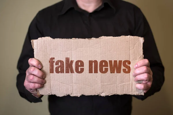 Muž Tmavé Košili Drží Kus Lepenky Textem Fake News — Stock fotografie