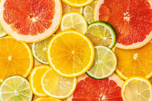 Mixed Fresh slices citrus fruit as background. Different types of citrus orange, lime,mandarin,grapefruit, lemon. Top view.
