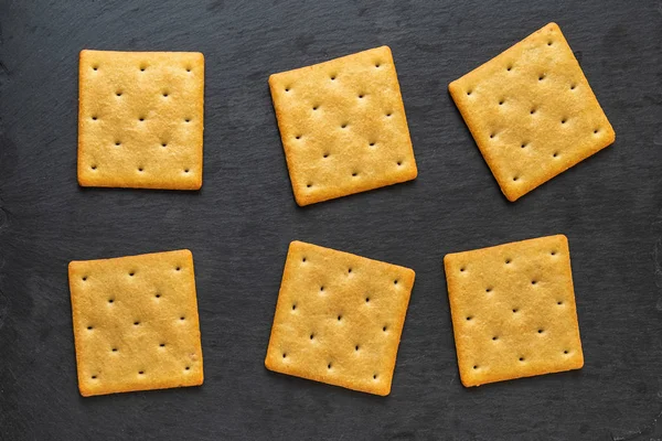 Set Dry Cracker Cookies Black Plate Top View — Stock Photo, Image