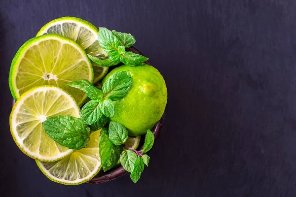 kireç dilimleri witn nane karanlık masada. Detoks diyeti.