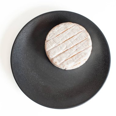 Beyaz yumuşak Brie peyniri. Camembert beyaz arka plan üzerinde üstten görünüm izole koyu plaka üzerinde.