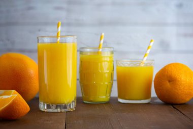 Taze portakal suyu bir bardak hafif ahşap zemin üzerinde. Yan görünüm.