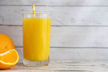 Cam, taze portakal suyu hafif ahşap zemin üzerinde. Yan görünümü. Kopya alanı ile.