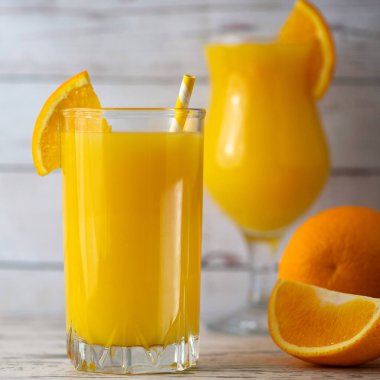 Taze portakal suyu bir bardak hafif ahşap zemin üzerinde. Yan görünüm.