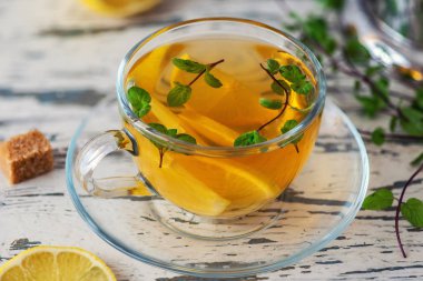 Limon dilimleri, şeker kamışı ve ahşap masa lambası nane limon çayı fincan. Yakın çekim.