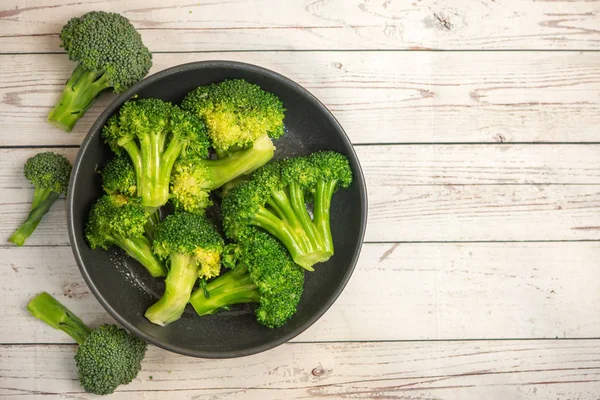 Mazzo Broccoli Verdi Freschi Piatto Nero Fondo Legno Chiaro Vista — Foto Stock