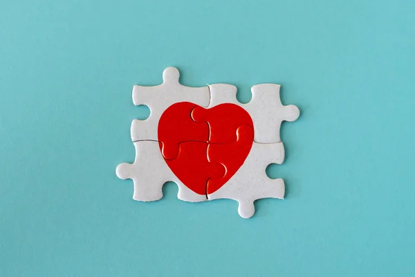 Nahaufnahme Von Vier Puzzleteilen Mit Rotem Herz Auf Blauem Pastellhintergrund — Stockfoto