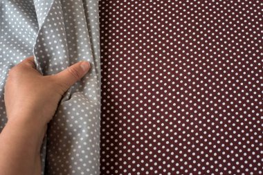 Arka plan olarak kahverengi kumaş üzerine gri kumaş dokunmadan el. Kopya alanı ile.