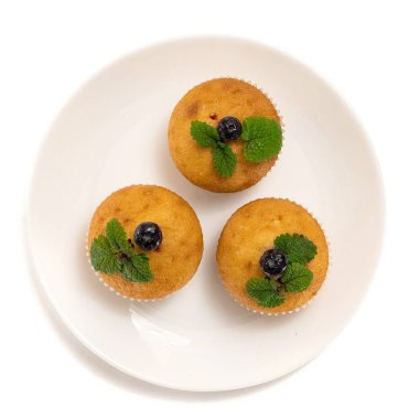 Blueberry muffins beyaz tabakta. Beyaz arka plan üzerinde izole. Üstten görünüm.