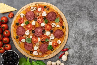 Peynir, mozzarella peyniri, mantar ve gri arka plan üzerinde salamlı pizza. Üstten görünüm.