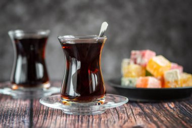 Türk cam çay bardak koyu ahşap masa üzerinde Türk lokumu ile için.