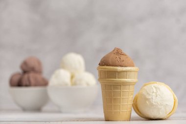 Vanilyalı ve çikolatalı dondurma kase ve gözleme bardak hafif arka plan üzerinde. Yan görünüm.