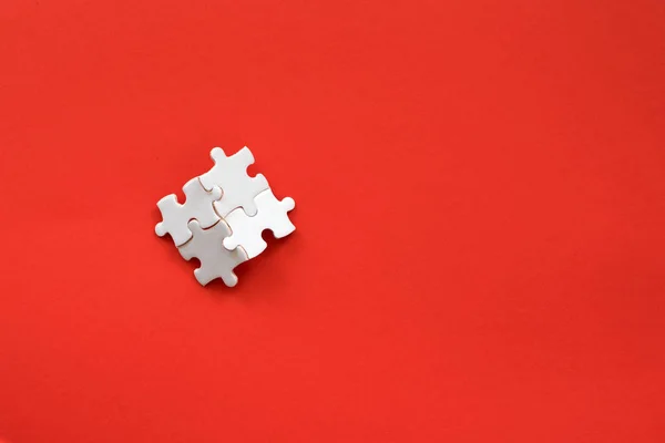 Szczegóły biały puzzle na czerwonym tle — Zdjęcie stockowe