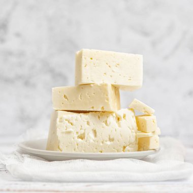 Beyaz peynir ışık arka plan üzerine dilimlenmiş. Yüksek anahtar. Kopya alanı ile