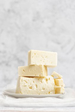 Beyaz peynir ışık arka plan üzerine dilimlenmiş. Yüksek anahtar. Kopya alanı ile