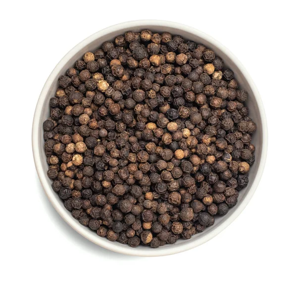Black dried pepper in bowl isolated on white background. Top view — Stock Photo, Image