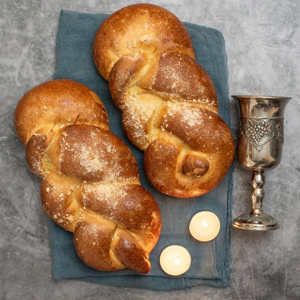 Shabbat Shalom - Pão de chalá, vinho shabbat e velas sobre fundo cinza. Vista superior — Fotografia de Stock