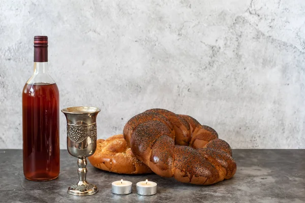 Shabbat Shalom - Pão de chalá, vinho shabbat e velas sobre fundo cinza. Com espaço de cópia — Fotografia de Stock