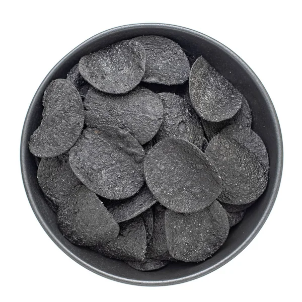 Patatas fritas crujientes negras en un tazón aislado sobre fondo blanco, vista superior — Foto de Stock