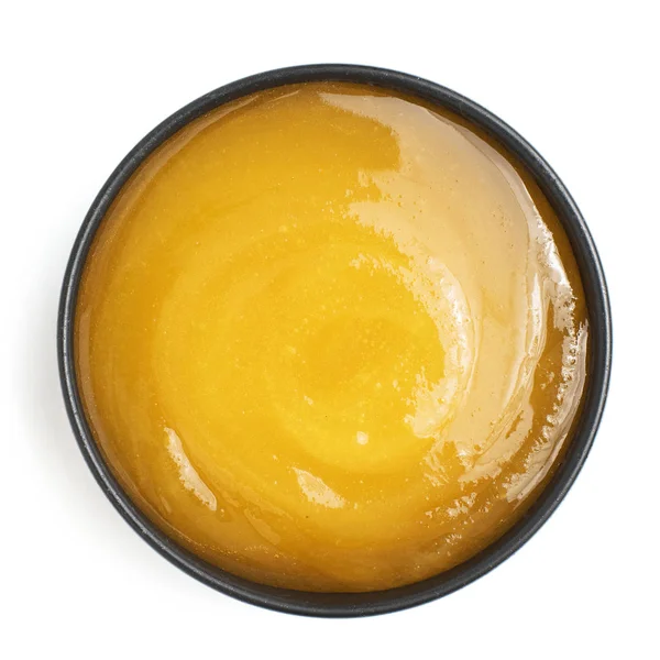 Miel gruesa en tazón oscuro sobre fondo blanco. Vista superior —  Fotos de Stock