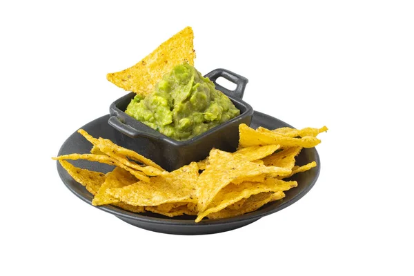 Grön Guacamole med nachos i mörk skål isolerad på vit bakgrund — Stockfoto