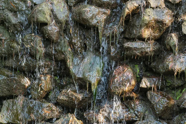 Steinmauern, Wasserfälle und Moos als Hintergrund. natürliche Textur — Stockfoto