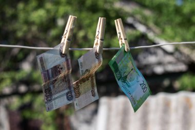 Para bir çamaşır iğnesi ile ipe bağlı.