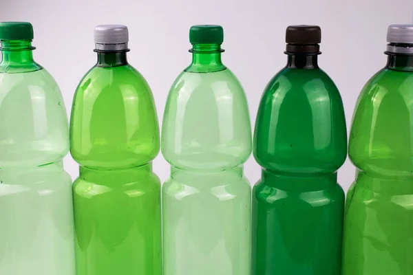 Beyaz arka planda beş plastik şişe.