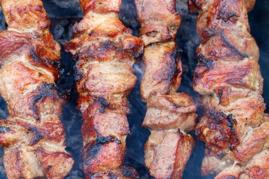 Şişler üzerinde marine edilmiş domuz eti parçaları ve kömürle pişirilmiş lanet kabuk. Sağlıklı beslenme kavramı.