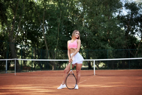 분홍색 치마를 금발의 여성은 여름에 코트에서 테니스 과가벼운 주황색 스포츠 — 스톡 사진