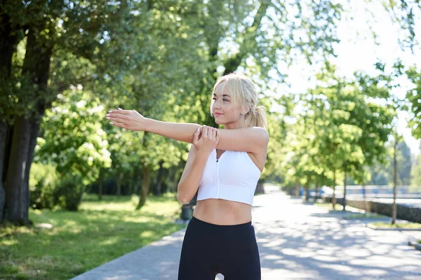Młoda Blondynka Ubrana Białe Czarne Legginsy Ćwicząca Poranne Ćwiczenia Parku — Zdjęcie stockowe