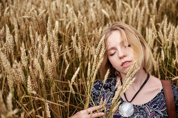 年轻的金发女人 穿着时髦的衣服 躺在地里 躺在麦秆上 在自然背景下的美丽女性的近照 生态旅游 创意肖像画 — 图库照片