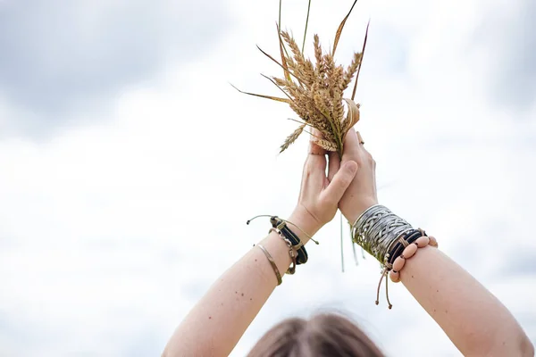 照片中 女人的手拿着五彩缤纷的手镯 把麦茎束在蓝天上 生态旅游概念 嬉皮士女孩在田野里放松 — 图库照片