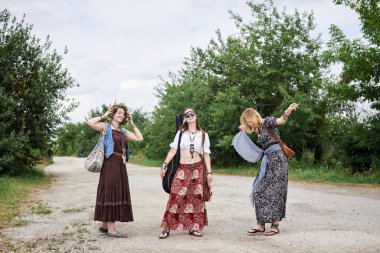 Üç hippi kadın, boho tarzı kıyafetler giyiyorlar, kırsalda toprak yolda yürüyorlar, dans ediyorlar, dinleniyorlar, eğleniyorlar. Arkadaşlar, yazın birlikte seyahat ediyoruz. Özgürlük ve mutluluk kavramı.