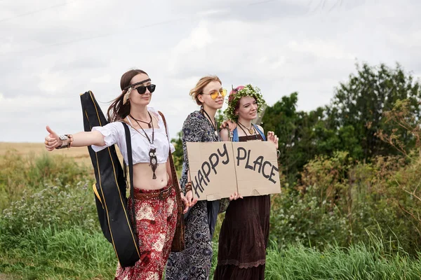 Üç hippi kadın, boho tarzı kıyafetler giyiyorlar, yolda dikiliyorlar, başparmak gezdiriyorlar, kartonda Happy Place yazan bir yere otostop çekiyorlar. Arkadaşlar, yazın birlikte seyahat ediyoruz. Özgürlük ve mutluluk kavramı.