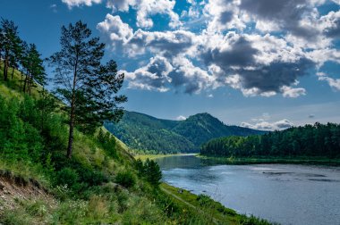 bulutların arasından nehir üzerinde güneş ışığı