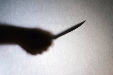 Soyguncular el siluet gri arka plan üzerinde izole büyük bıçak. Cinayet, soygun, suç