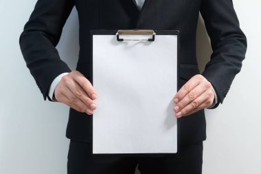 tabela, kırpma yolu, metin için yer tutarken bir takım elbise giymiş genç iş adamı