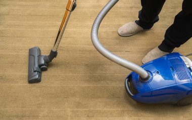 Modern bir elektrikli süpürge halı vakumlama sırasında kullanılan karanlık Başkanı. Temizlik hizmet anlayışı. Elektrikli süpürge ile halı boya işlemi
