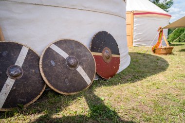 Yanındaki beyaz çadır savaşlarda kullanılan yakın dövüş için Ortaçağ ağaç ve metal kalkanlar