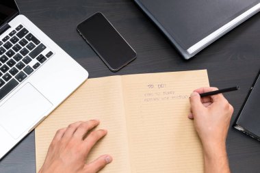 Ofis masaları ile genel gider görünümünü vintage dizüstü bilgisayar, bilgisayar klavye, tablet pc ve smartphone üzerinde kalemiyle listelemek yazma el mans. metin için yer kopyalayın. iş Ofis İşyeri