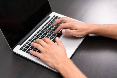 Bir adam vintage ahşap masa üzerinde bir dizüstü bilgisayar kullanarak çalışıyor. Tipik bir klavye üzerinde eller. Üstten görünüm, iş Ofis İşyeri