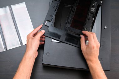 Profesyonel teknisyen el negatif film ve slaytlar, eski analog fotoğrafçılık film teknolojisi, işyeri vintage ahşap masa üzerinde digitising tarama
