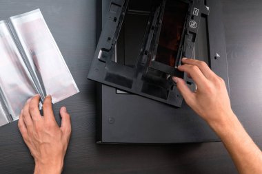 Profesyonel teknisyen el negatif film ve slaytlar, eski analog fotoğrafçılık film teknolojisi, işyeri vintage ahşap masa üzerinde digitising tarama