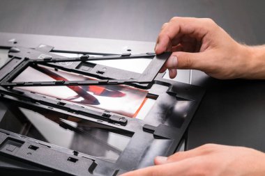 Profesyonel teknisyen el negatif film ve slaytlar, eski analog fotoğrafçılık film teknolojisi, işyeri vintage ahşap masa üzerinde digitising tarama