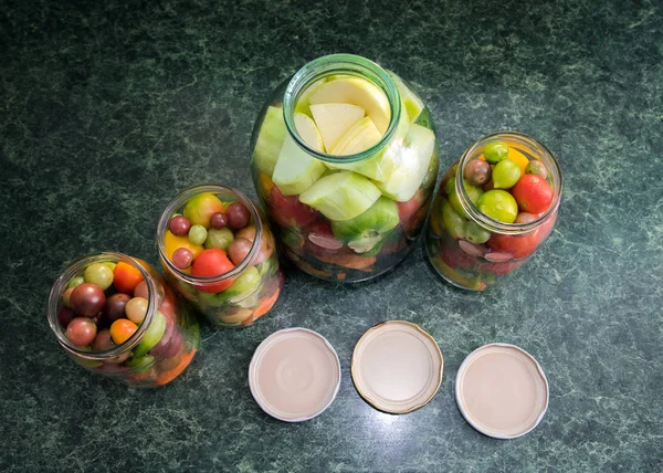 Jars of pickled vegetables. Traditional marinated food - tomatoes, pickles, onions