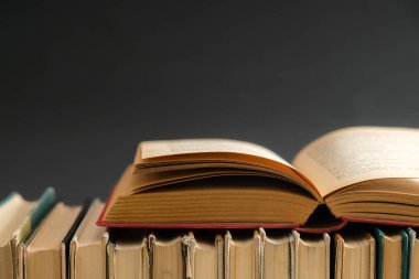 Siyah arka plan, ahşap masa ciltli kitap açık kitap. Eğitim ve arka plan öğrenme. Okul için okuyor. Metin için yer kopyalayın